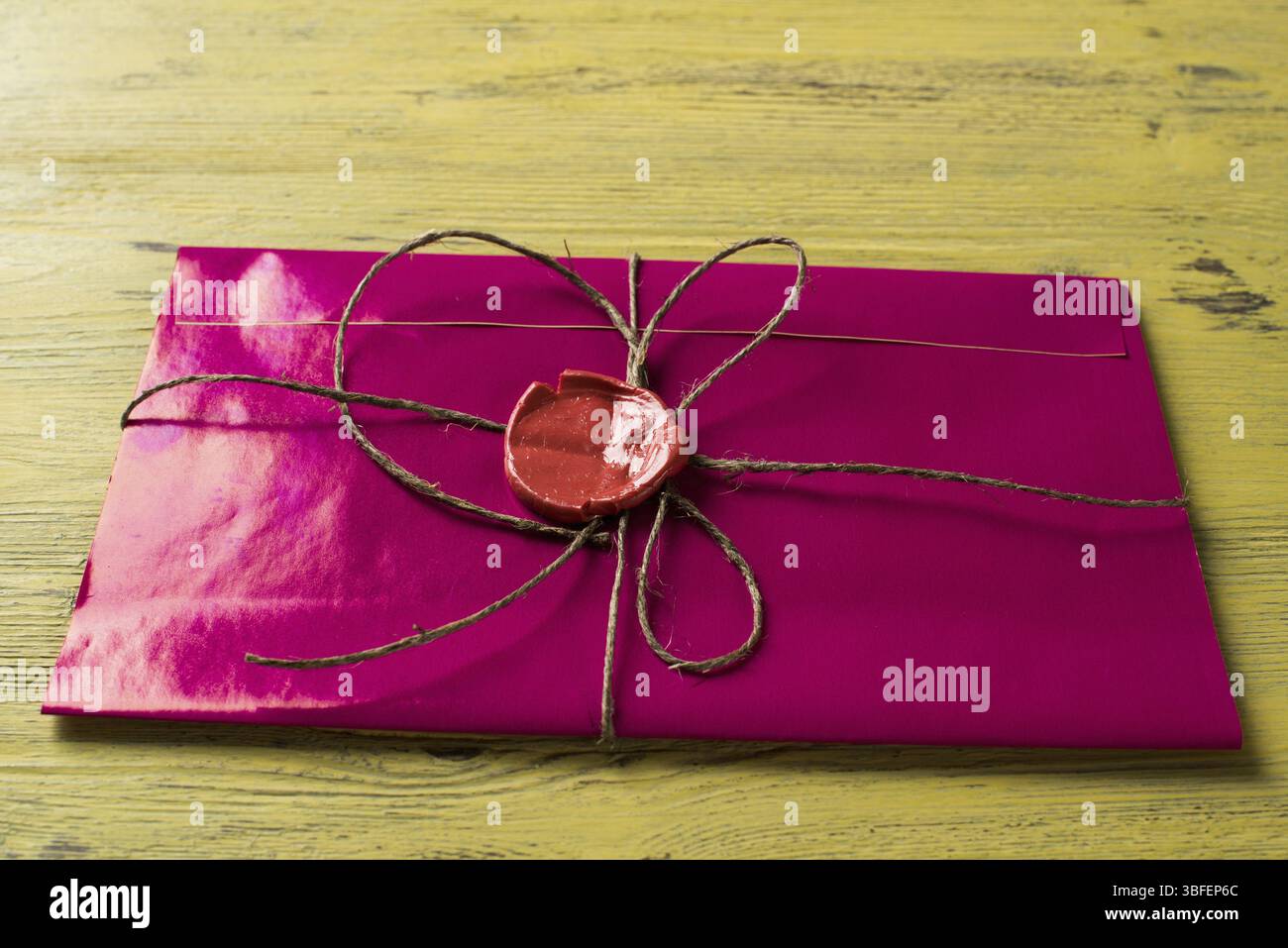 Lettre rose enveloppe avec cachet de cire sur la surface en bois Banque D'Images
