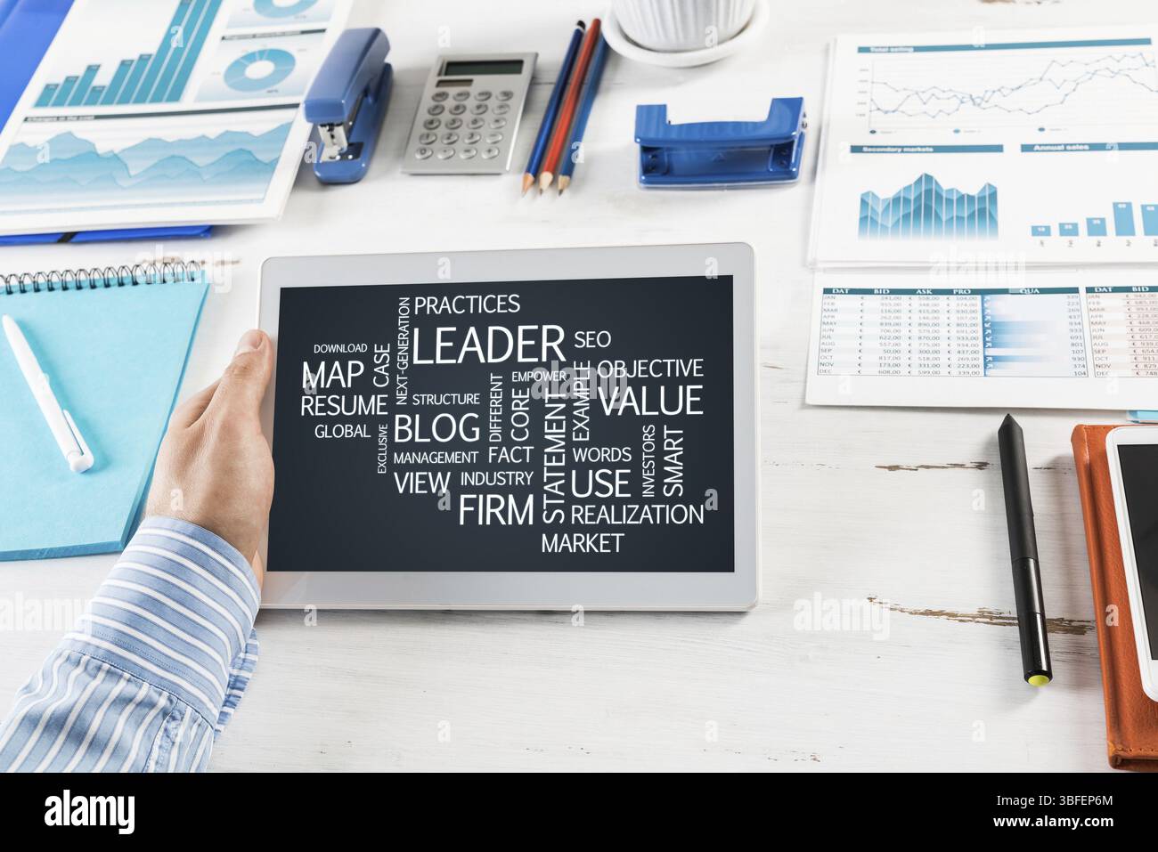 Gros plan, mains masculines avec comprimé. Homme d'affaires travaillant à la table dans le bureau Banque D'Images