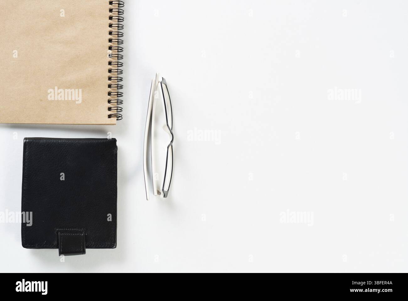 Nature morte de l'espace de travail de bureau moderne avec des fournitures. Bureau blanc plat avec portefeuille en cuir noir et bloc-notes en spirale. Comptabilité et service bancaire. Banque D'Images