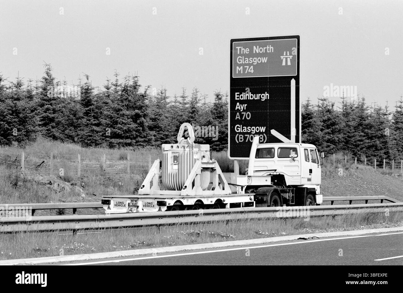 Rare observation d'une fiole Unifetch de l'UKAEA (United Kingdom Atomic Energy Authority) contenant du combustible irradié pour réacteur de recherche (peut-être de Harwell) en route vers l'usine de retraitement de Dounreay, en Écosse. Photographié en direction du nord sur l'A74 (aujourd'hui la M74) entre Carlisle et Glasgow en 1989. Banque D'Images