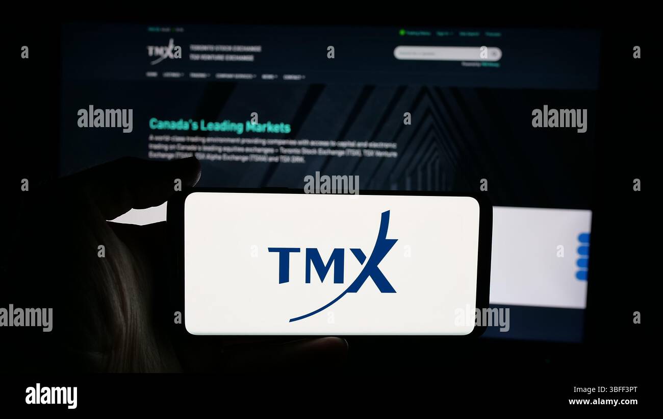 Stuttgart, Allemagne - 01-20-01 2025 : personne tenant un téléphone cellulaire avec le logo de la société boursière canadienne TMX Group Limited sur l'écran devant la page Web Banque D'Images