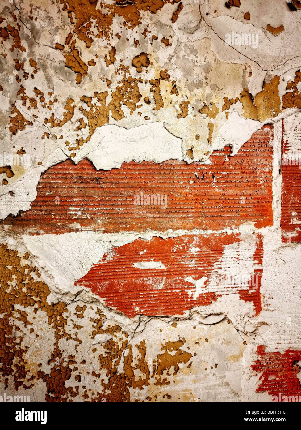 La surface présente une combinaison de peinture pelable et de briques apparentes, soulignant l'âge et le caractère du bâtiment. - Image de stock capturée avec un smartphone