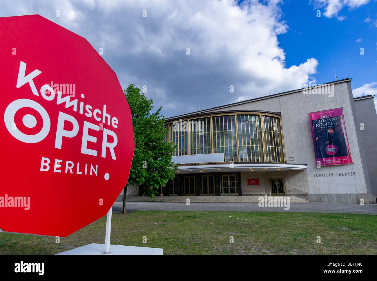 Komische Oper Berlin au Schiller Theater avec un signe rouge audacieux et une affiche Don Giovanni Requiem sous le ciel nuageux. Banque D'Images