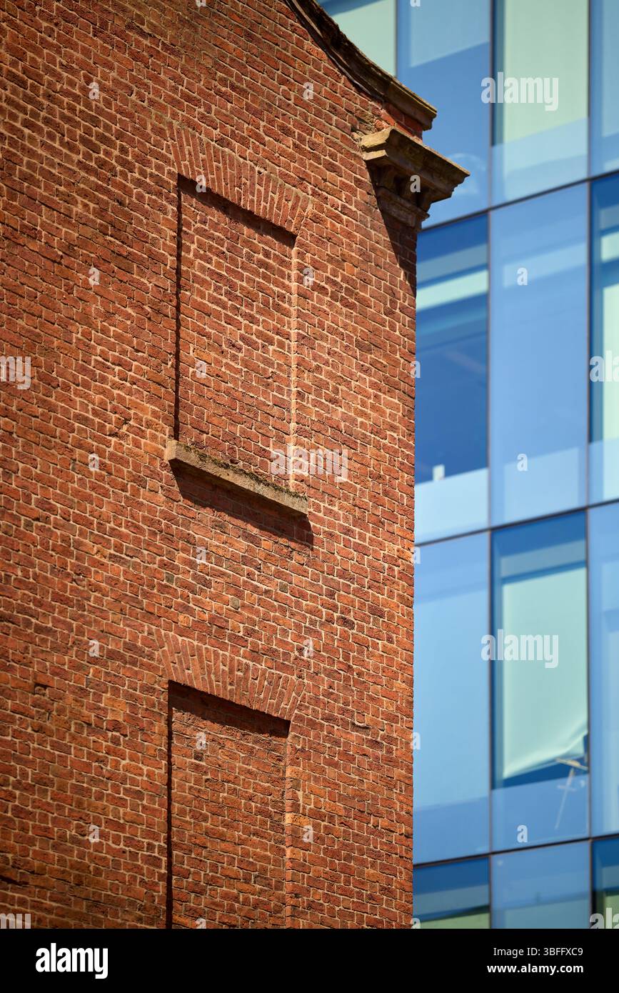 Manchester ancien et neuf, le bâtiment en briques rouges contraste avec le nouveau bâtiment revêtu de verre Banque D'Images