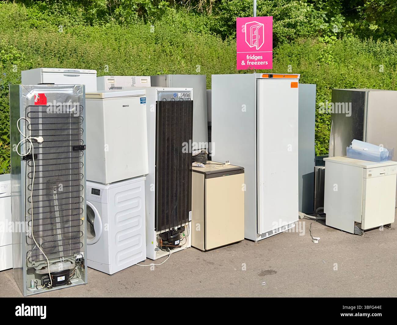 Vieux réfrigérateurs et congélateurs alignés pour le recyclage sur un site d'élimination des déchets, point de collecte des appareils extérieurs Banque D'Images