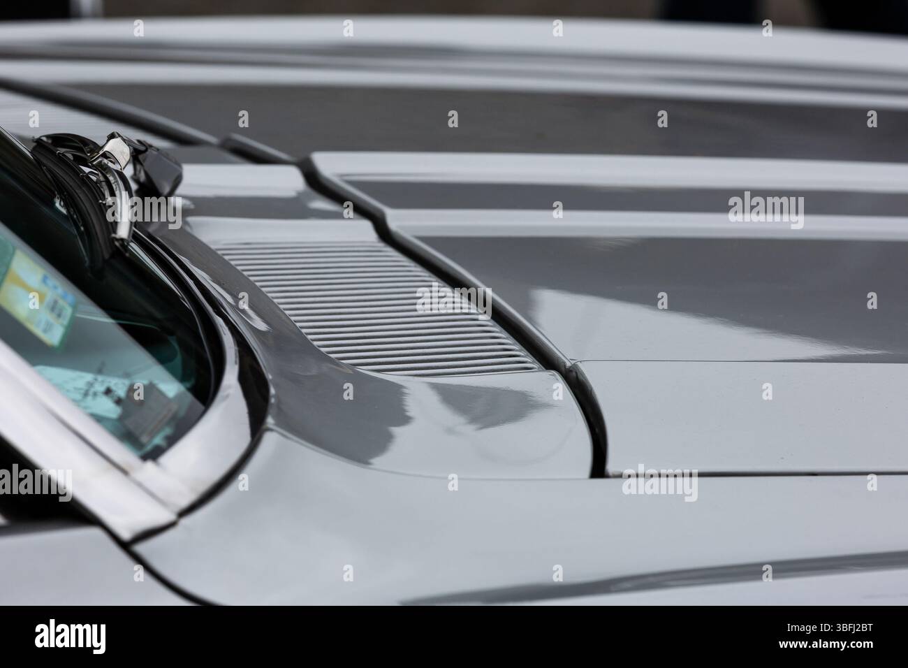 Capot gris, pare-brise en verre et essuie-glace d'une voiture classique Banque D'Images Capot gris, pare-brise en verre et essuie-glace d'une voiture classique Banque D'Images