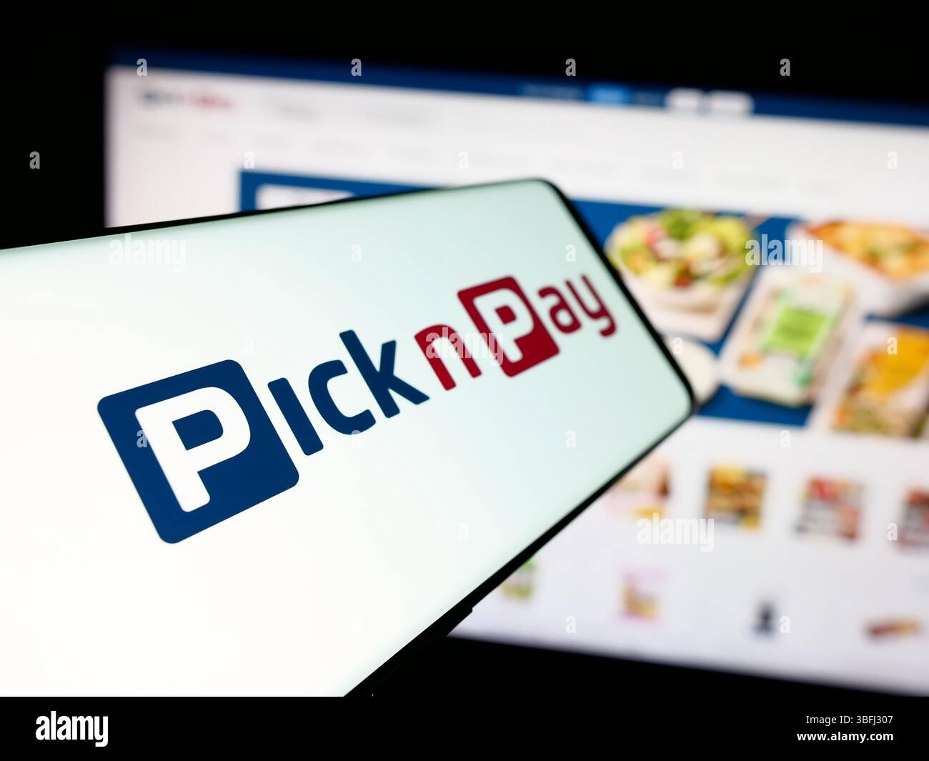 Dans cette illustration photo, un smartphone avec le logo de la société de vente au détail d'épicerie Pick n Pay Group Ltd est vu sur l'écran devant le site Web. Banque D'Images