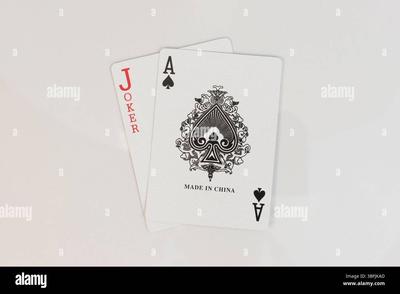 As de pique et cartes à jouer joker rouge sur fond blanc Banque D'Images