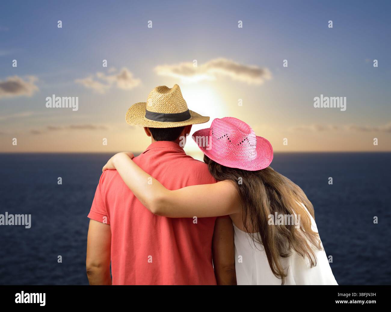 Embrasser le couple et regarder le soleil au coucher du soleil sur la plage Banque D'Images