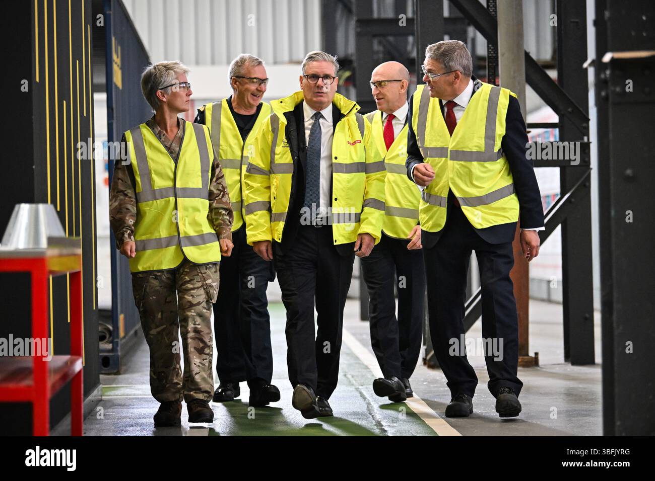 Le premier ministre Keir Starmer (au centre), le secrétaire à la Défense John Healey (deuxième à droite) et le directeur général de l'entreprise de navires de BAE Systems Simon Lister (à droite) s'adressent à un membre du personnel lors d'une visite à BAE Systems à Govan, Glasgow, pour lancer l'examen de la défense stratégique. Date de la photo : lundi 2 juin 2025. Banque D'Images