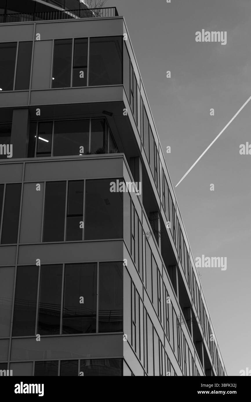 Avion passant derrière un bâtiment. Banque D'Images