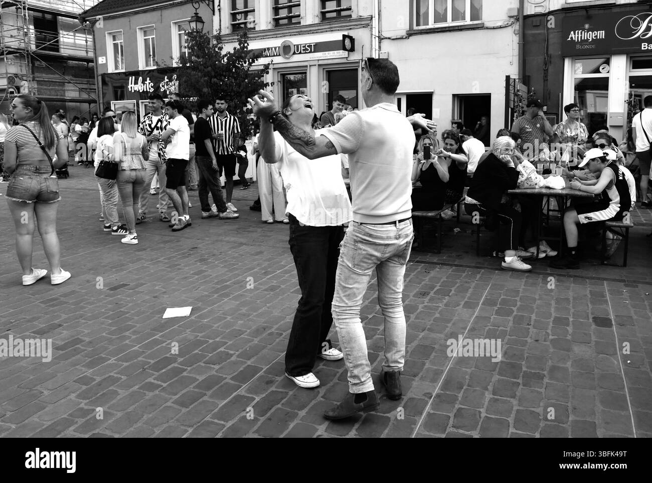 Couples dansant dans la rue pendant le jour de mai célébrations de la Fête du Muguet (jour de la Lilly de la Vallée) le jour de la fête du travail à Guines dans le nord de la France 2025 Banque D'Images