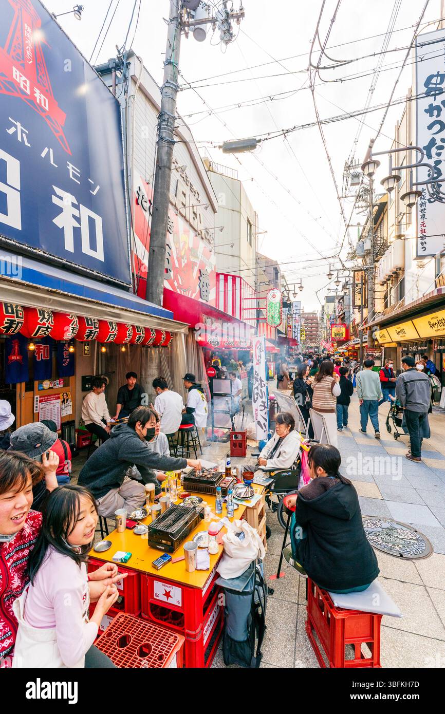 Famille assis à table à l'extérieur du Restaurant Yakiniku hormone Showa, en utilisant des grillades portables pour cuire la viande, c'est ce qu'on appelle yakiniku, viande grillée. Banque D'Images