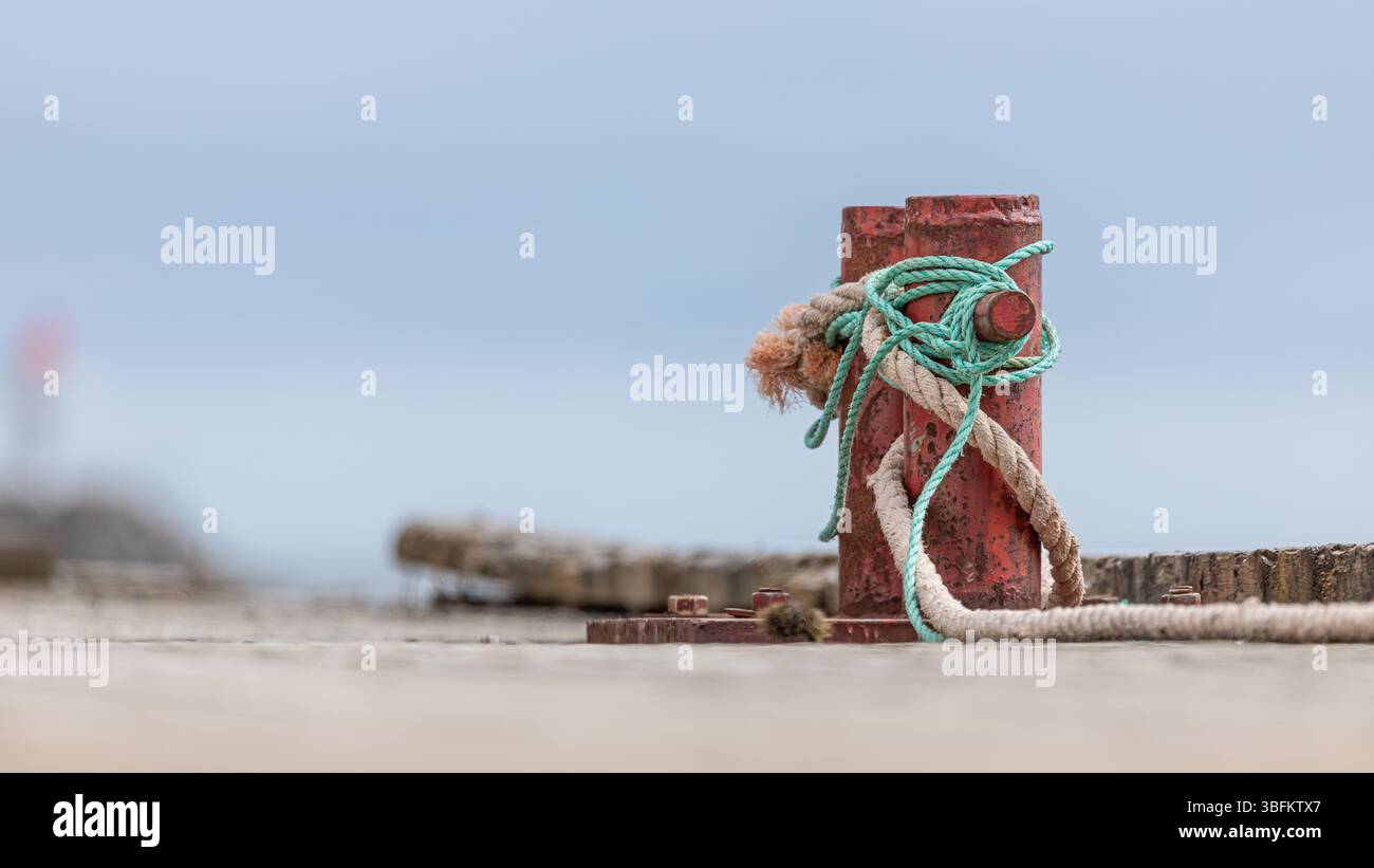 Borne en métal rouillé sur la jetée en bois avec fond flou sur la côte norvégienne Banque D'Images