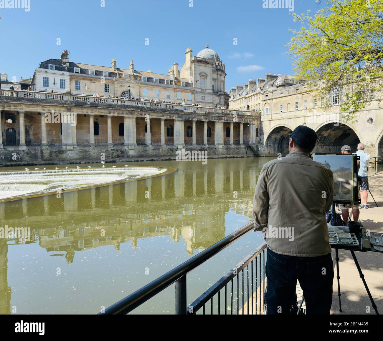 BATH, ANGLETERRE – 17 MAI 2025 : un artiste peint le long de la rivière Avon avec une toile de fond d'architecture historique et de ponts. Banque D'Images BATH, ANGLETERRE – 17 MAI 2025 : un artiste peint le long de la rivière Avon avec une toile de fond d'architecture historique et de ponts. Banque D'Images