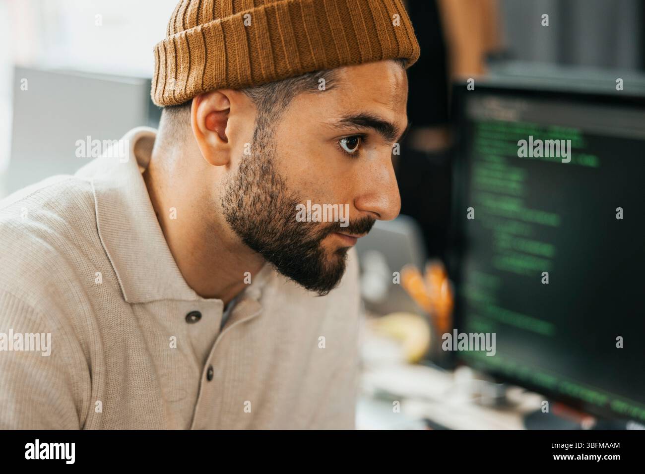 Entrepreneur masculin concentré envisageant au bureau de démarrage de technologie Banque D'Images