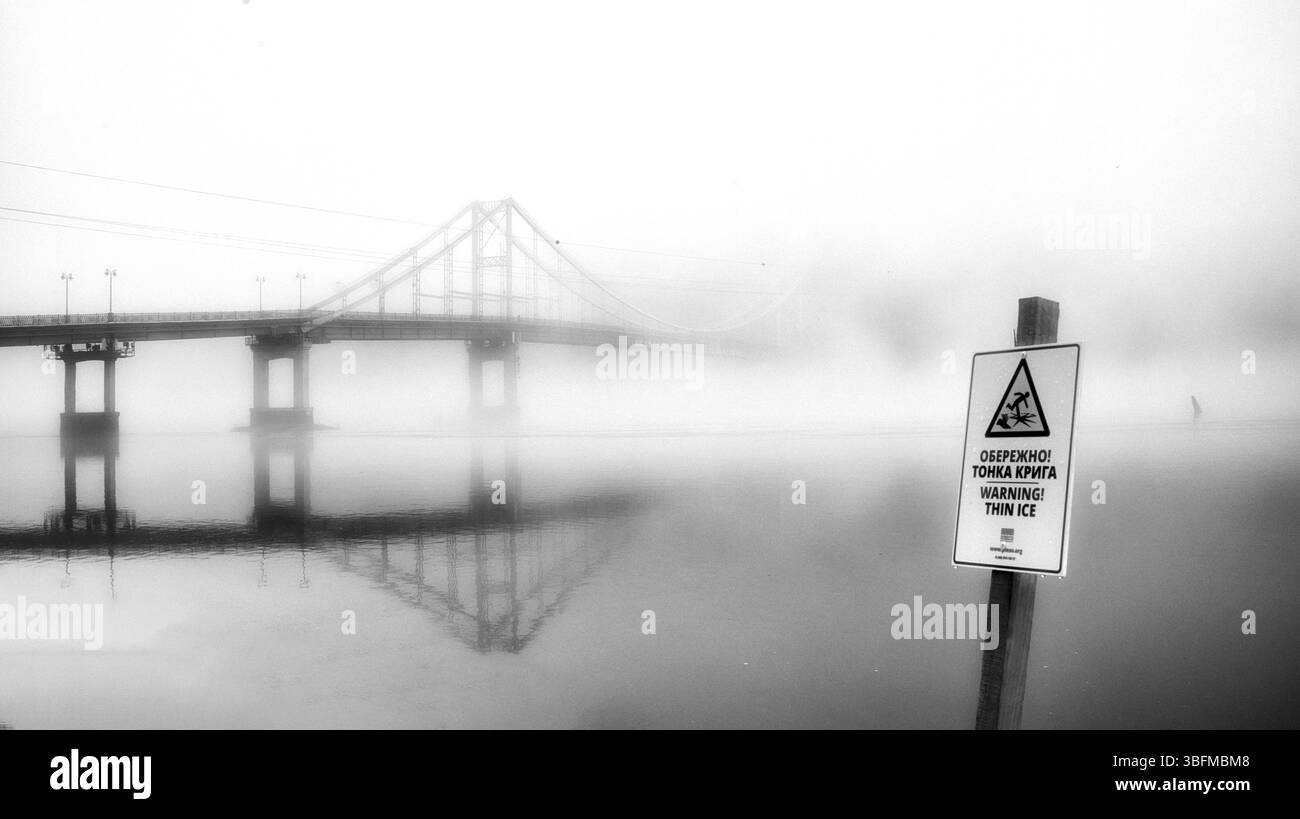 Un pont solitaire émerge de l'étreinte éthéré de la brume. Banque D'Images