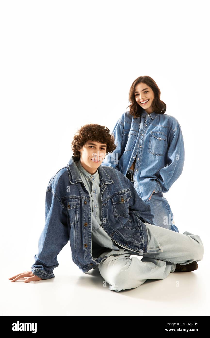 Un jeune couple élégant rayonne d'amour dans un denim tendance sur un fond lumineux. Banque D'Images