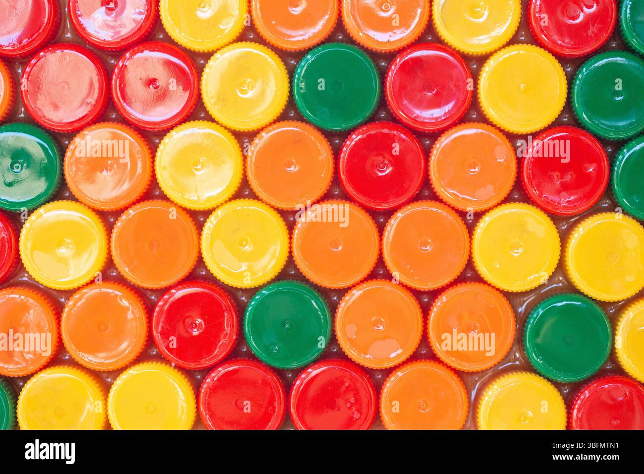 Fond coloré de bouchons de bouteille. Motif plastique brillant. Concept de recyclage. Texture des déchets plastiques. Vue de dessus des couvercles ronds colorés. Banque D'Images
