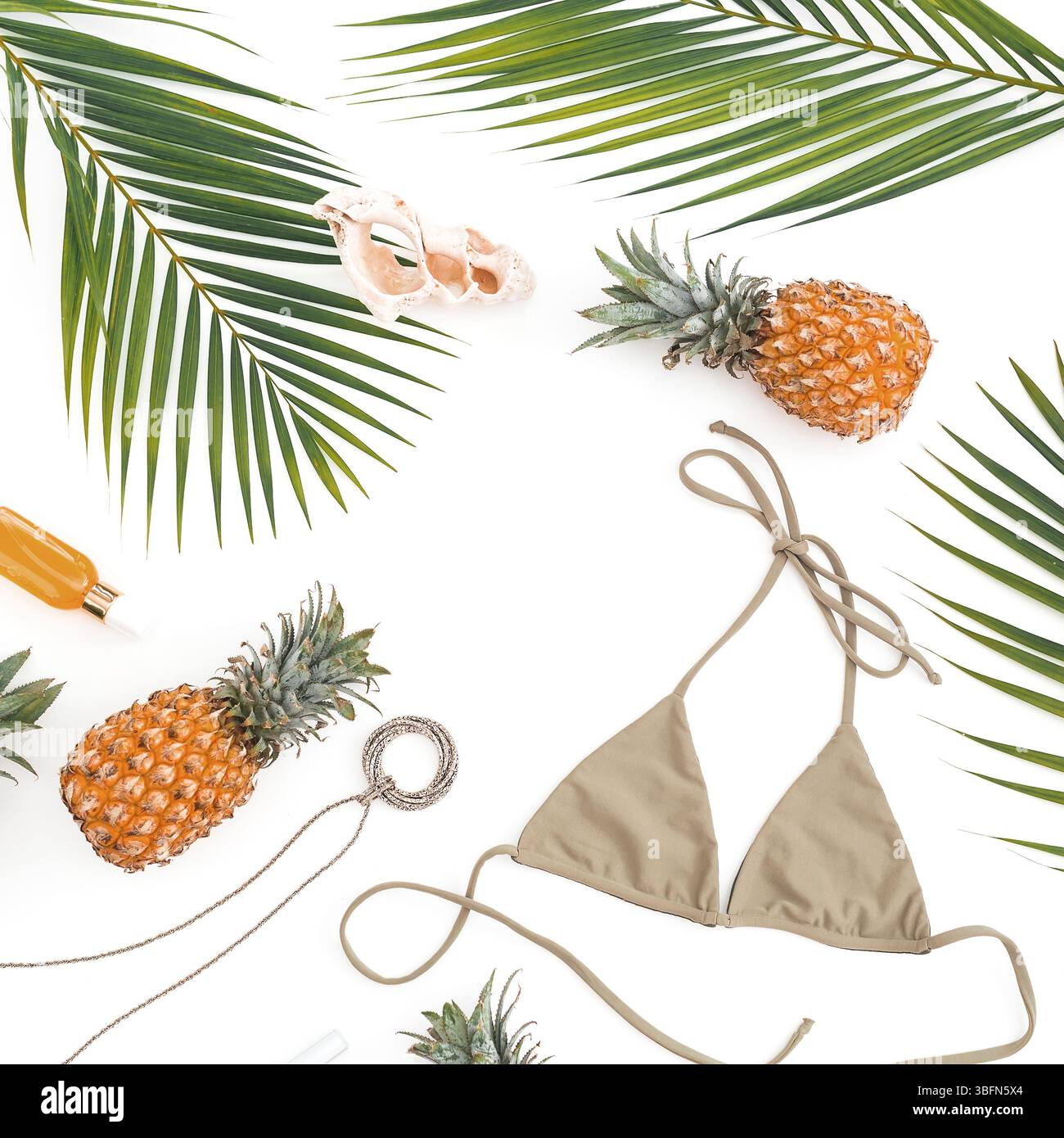 Concept de vacances féminin - ananas, cosmétique avec bikini sur blanc. Plat, vue de dessus. Banque D'Images