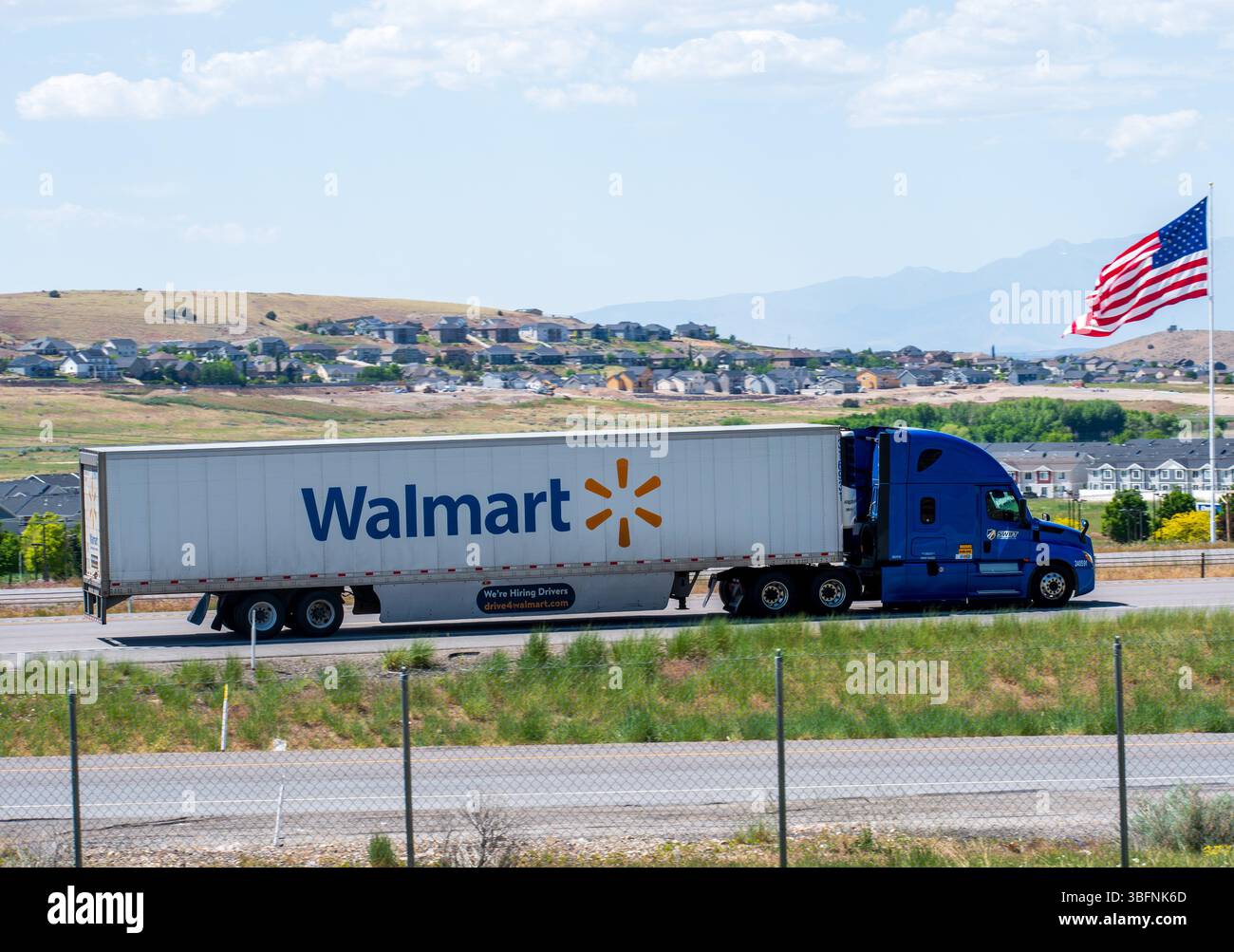 Santaquin, Utah – 2 juin 2025 : une remorque Walmart se déplace vers le nord sur l'Interstate 15 devant un drapeau américain à Santaquin, Utah, États-Unis. Banque D'Images