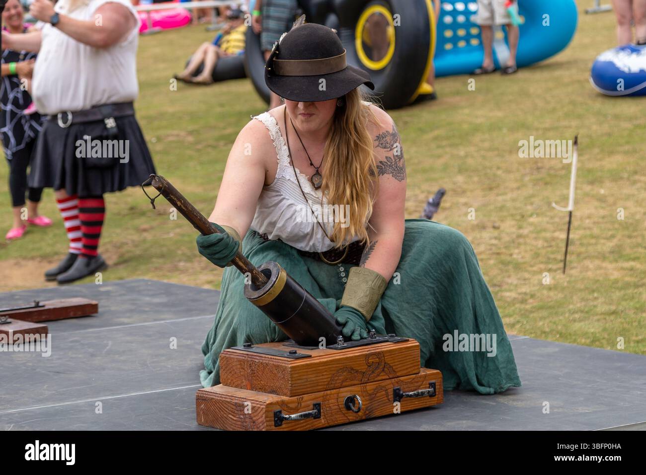 The Big Float, Portland, Oregon - 13 juillet 2019 : une femme en tenue steampunk charge un petit canon sur une scène du festival. Banque D'Images