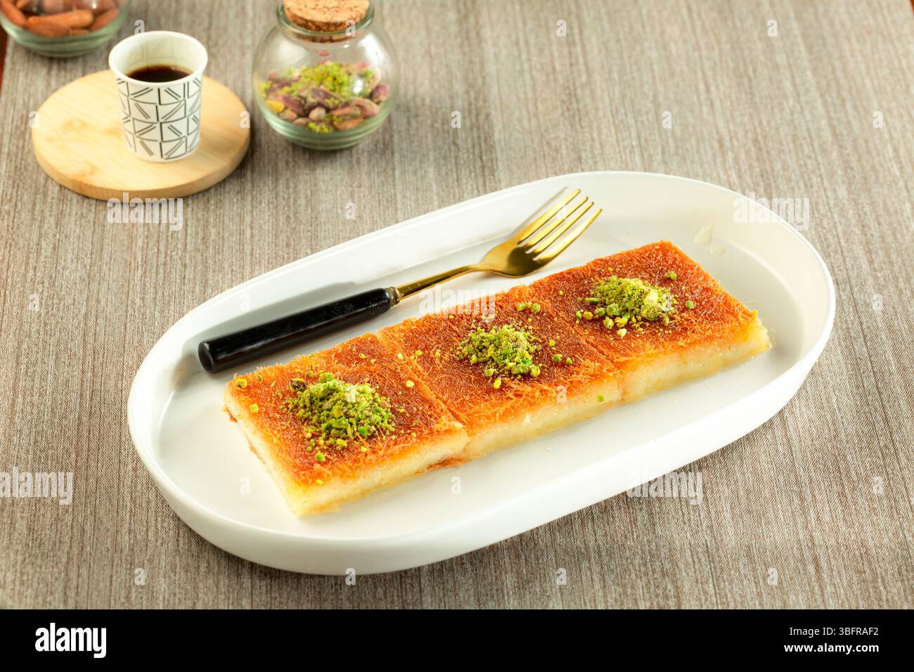 Kunafa avec de la crème et des fils de pâtisserie fins, sucré avec du sirop, dessert arabe traditionnel Banque D'Images