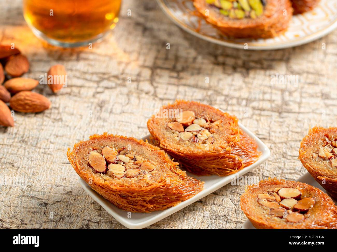 Assortiment de rouleaux de noix avec kunafa aux amandes, pâtisseries sucrées en couches, desserts arabes traditionnels Banque D'Images