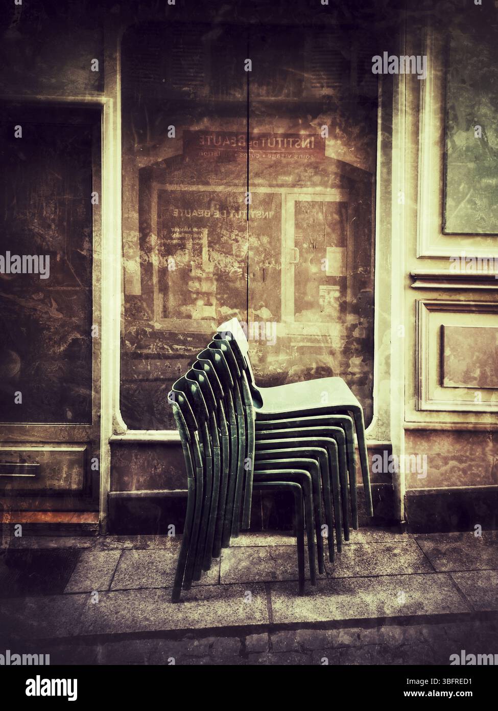 Les chaises empilées s'appuient contre l'extérieur du bâtiment accueillant, capturant l'ambiance paisible d'une rue en début de soirée. - Image de stock capturée avec un smartphone