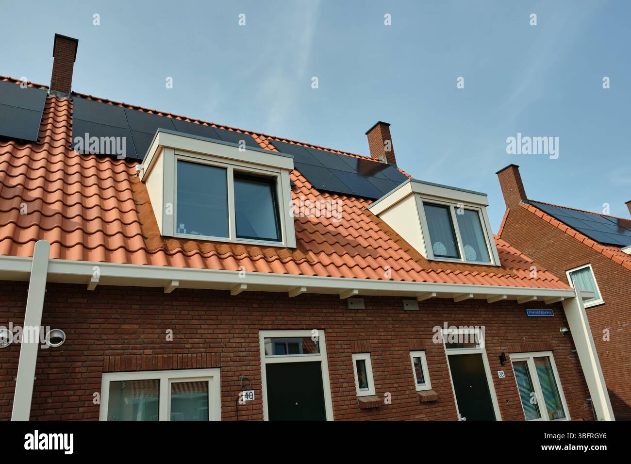 Juin 1, 2025 - Middelburg-pays-Bas : bloc typique de logements sociaux 1930 avec des panneaux solaires répétitifs à travers plusieurs maisons, et de nouvelles lucarnes, Offerin Banque D'Images