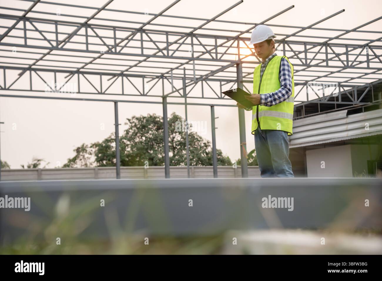inspecteur ou ingénieur inspecte la maison de construction à l'aide d'une liste de contrôle. Les ingénieurs et architectes ou les contacteurs comptent les matériaux pour la construction. Buil Banque D'Images
