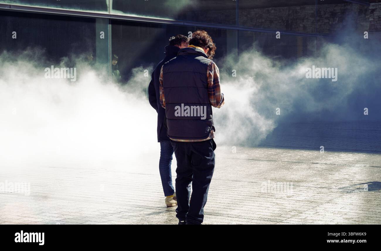 Deux visiteurs se tiennent debout alors que du brouillard apparaît autour d’eux dans l’installation Seeing Sound, Hearing Time de Ryuichi Sakamoto Banque D'Images