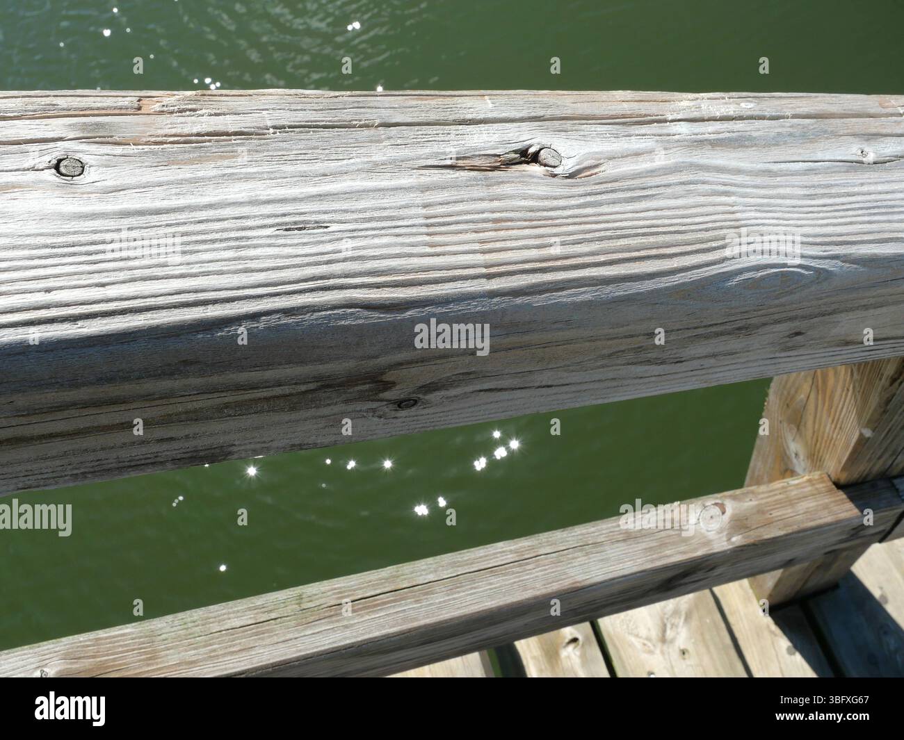 Main courante en bois altéré avec texture forte sur le pont du port. Idéal pour les arrière-plans. Copyspace. Banque D'Images