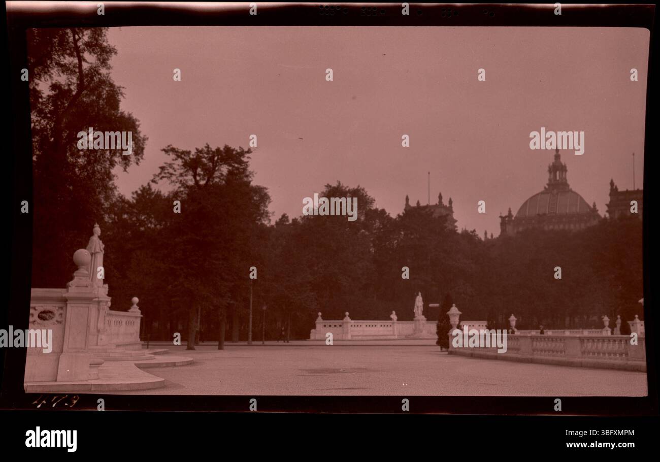 Cette photographie de 1913 montre les statues et les balustrades en marbre marquant l'entrée du parc Tiergarten de Berlin. La porte de Brandebourg et le dôme du Reichstag sont visibles en arrière-plan. Les Arrases ont capturé ces monuments berlinois lors de leur tournée européenne de 1913. Banque D'Images