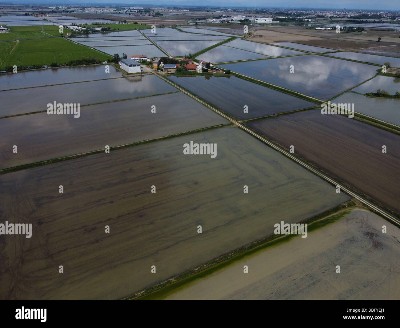 Vue par drone de la campagne de Novara avec des rizières inondées reflétant le ciel - emblématique de l'utilisation des terres agricoles locales. Banque D'Images