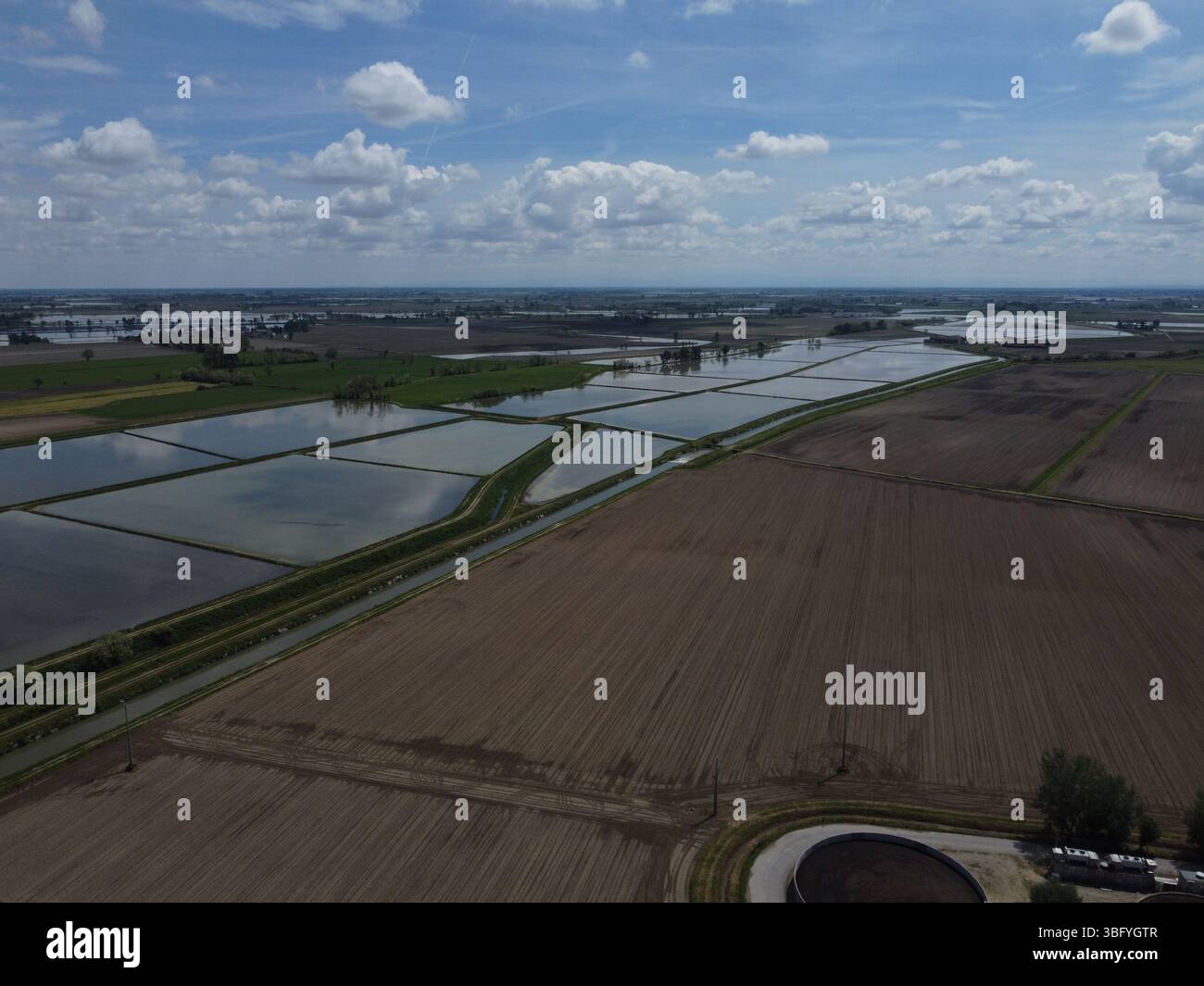 Vue par drone de la campagne de Novara avec des rizières inondées reflétant le ciel - emblématique de l'utilisation des terres agricoles locales. Banque D'Images