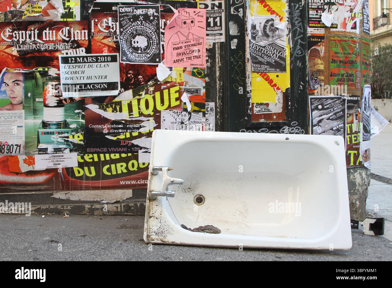 Baignoire abandonnée et affiches sur un mur dans les rues de Lyon France en 2010 Banque D'Images