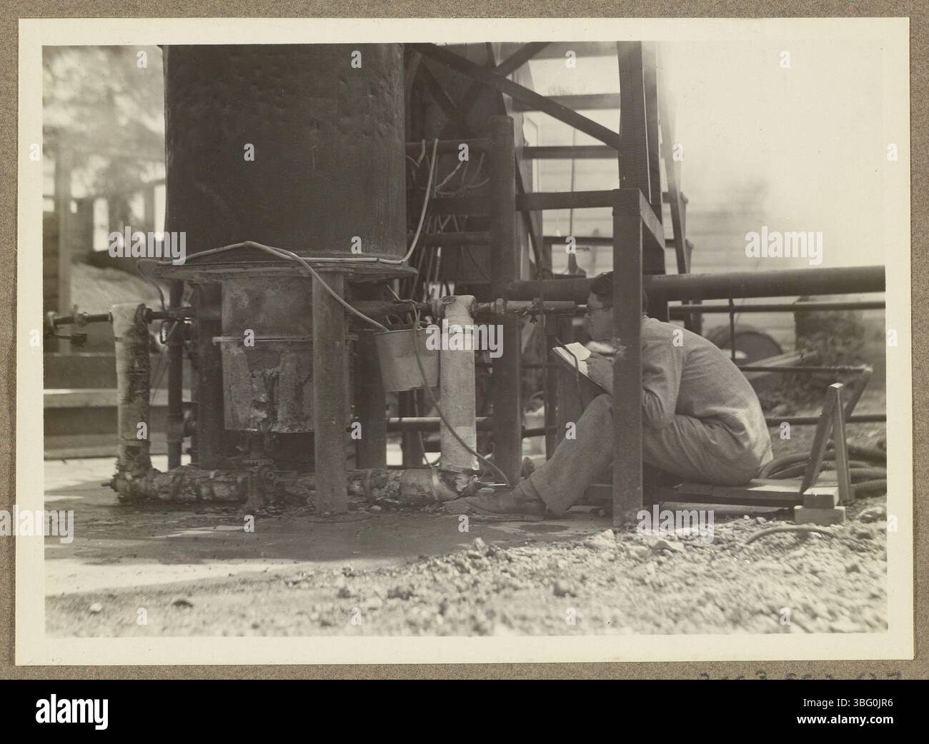 Une image en gros plan de Travis P. Hignett utilisant un pyromètre optique pour mesurer la température de combustion du coke dans le haut fourneau du Fixed Nitrogen Research Laboratory du Département de l'Agriculture des États-Unis, créé en 1919. Le laboratoire s'est concentré sur les produits azotés atmosphériques comme les munitions et les engrais. Banque D'Images