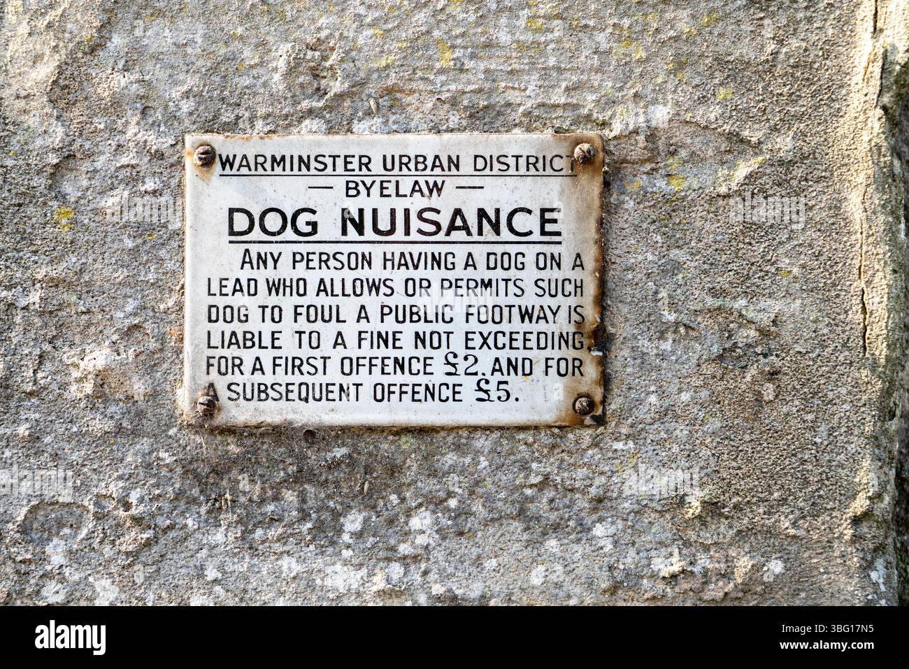 Vieux signe de nuisance de chien sur un mur de pierre Banque D'Images