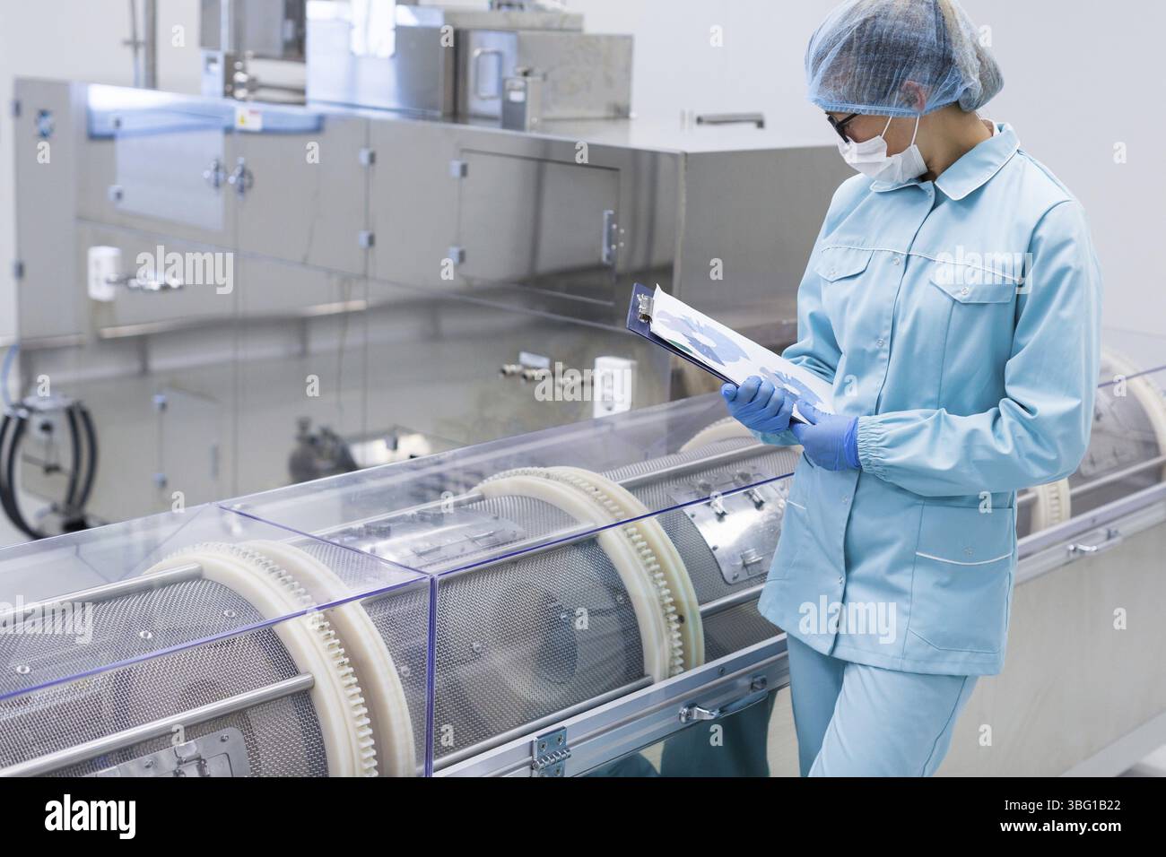 L'ouvrier de l'usine vérifie les lectures de la machine Banque D'Images