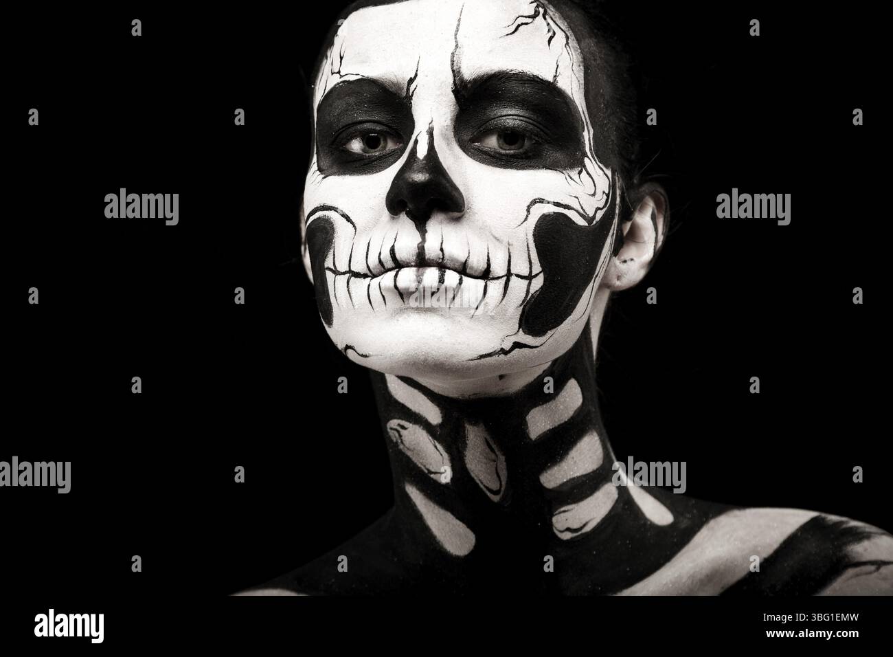 Isolé sur noir, photo en gros plan, belle jeune brune femme caucasienne avec l'art du corps scull, les yeux gris, les yeux à moitié fermés Banque D'Images