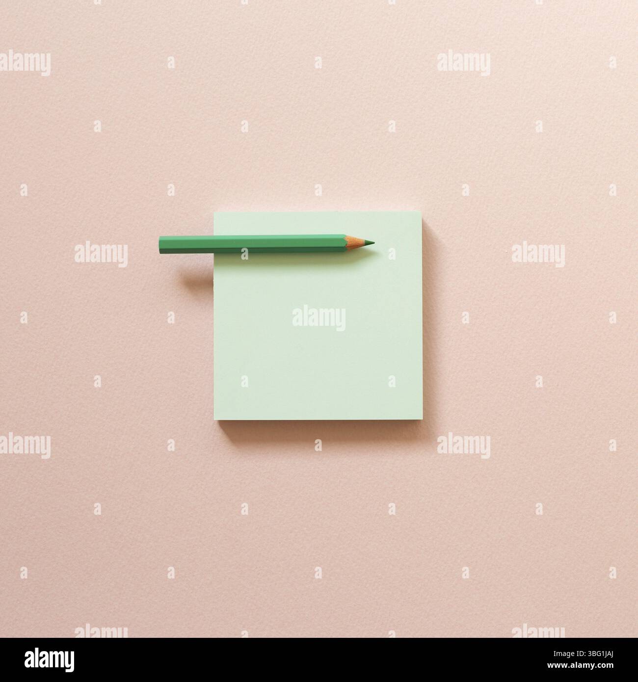 Papier mémo vert, notes adhésives avec crayon de couleur sur fond rose. Vue du dessus, espace de copie Banque D'Images
