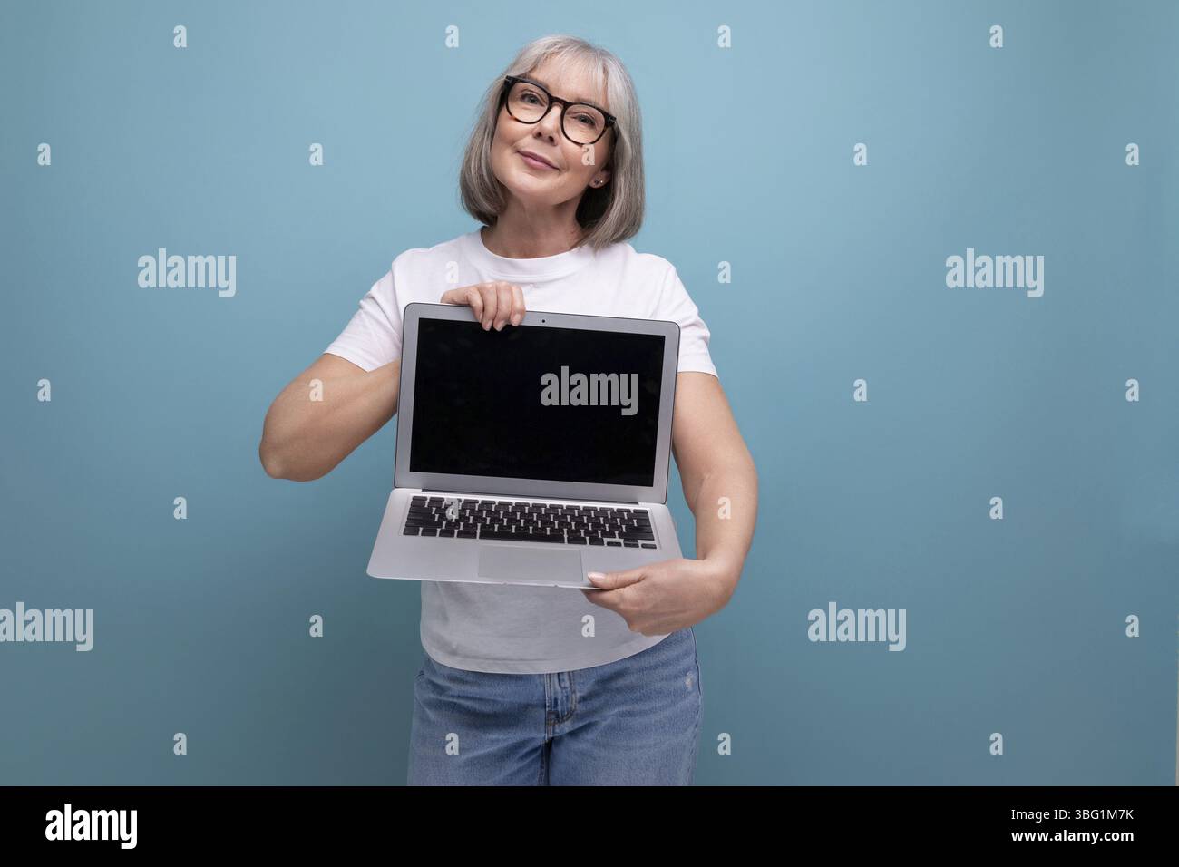 Entreprise d'âge moyen. femme d'âge moyen avec la technique d'ordinateur portable des maîtres de cheveux gris sur fond de studio avec espace de copie Banque D'Images