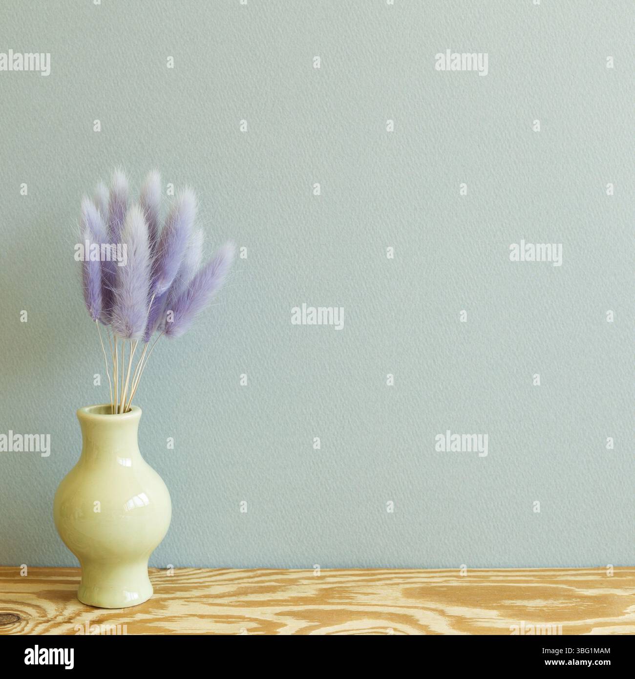 Vase de pourpre lièvres queue herbe fleurs sèches sur table en bois. Fond de mur menthe. Espace de copie Banque D'Images