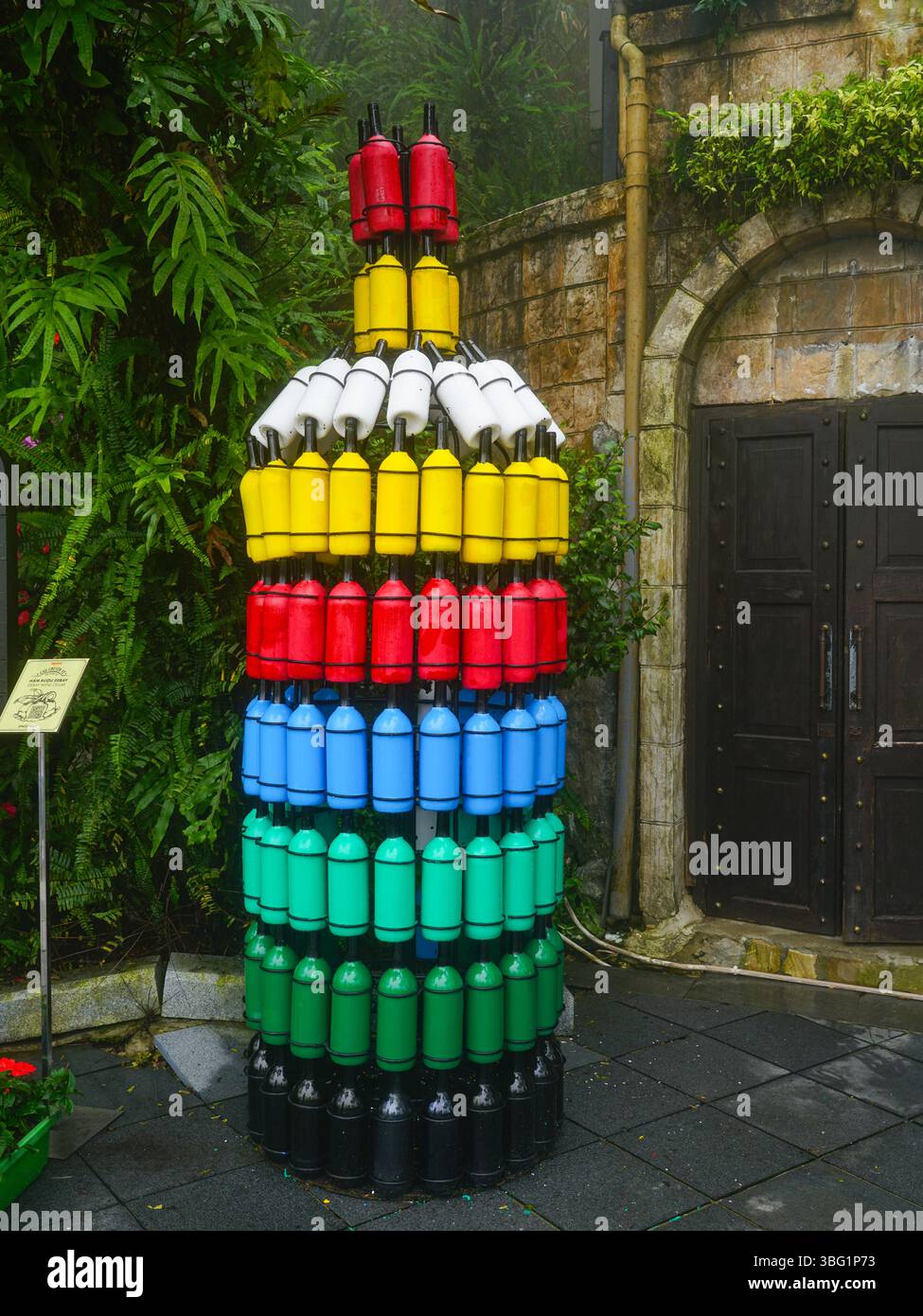BA Na Hills, Vietnam - 17 mars 2025 : une pyramide colorée en forme de bouteille faite de bouteilles de vin à l'entrée d'une ancienne cave Banque D'Images