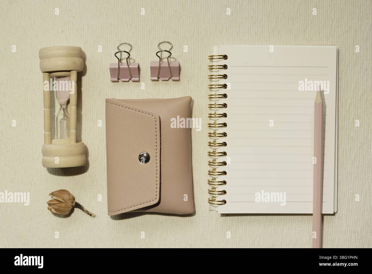 Fournitures roses. Verre de sable, housse, clip, carnet, crayon de couleur sur le bureau. pose à plat, vue de dessus Banque D'Images