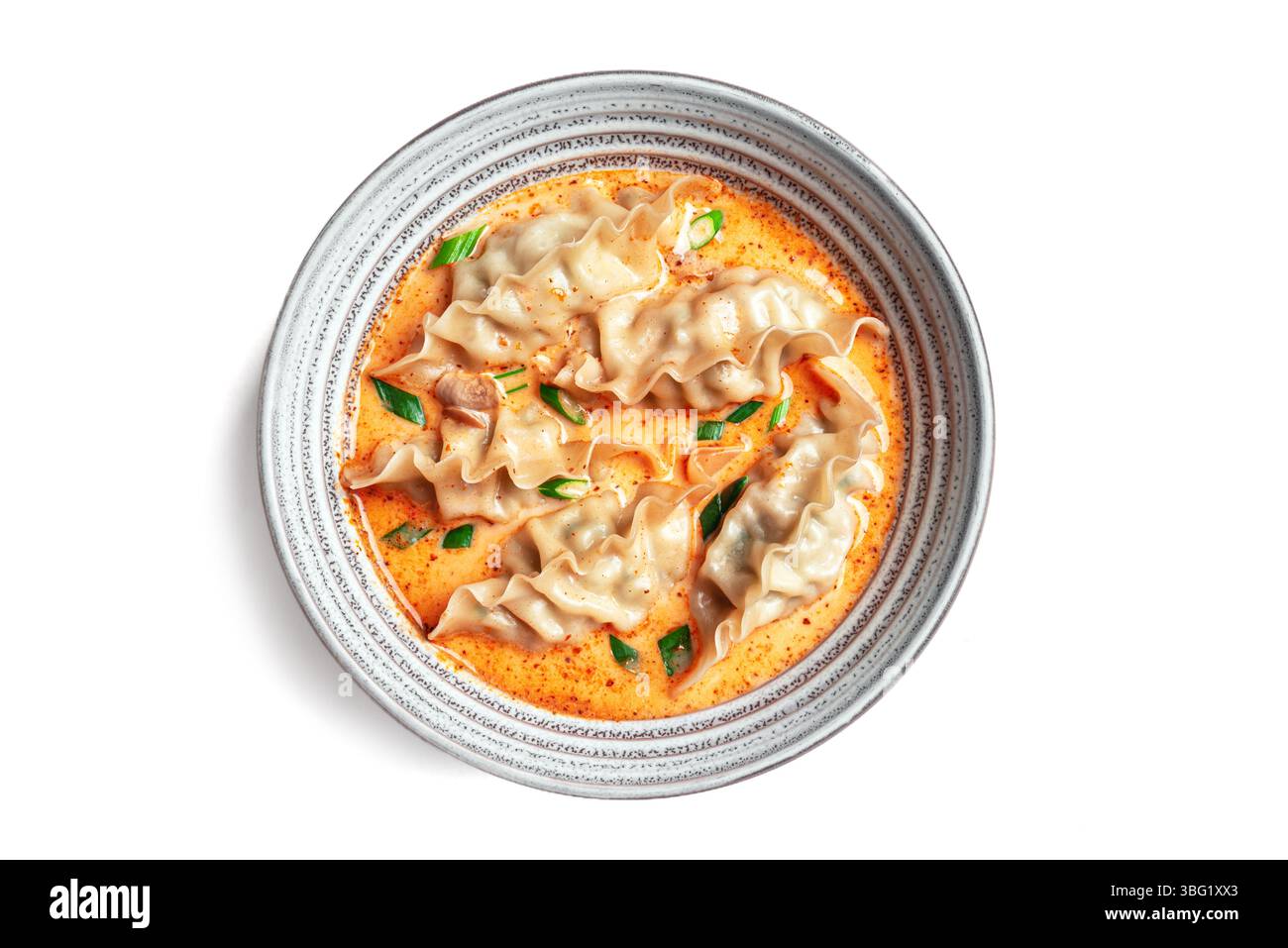 Soupe de boulettes au curry de noix de coco thaïlandaise isolée sur fond blanc, vue de dessus. Bol de soupe wonton au curry rouge. Banque D'Images