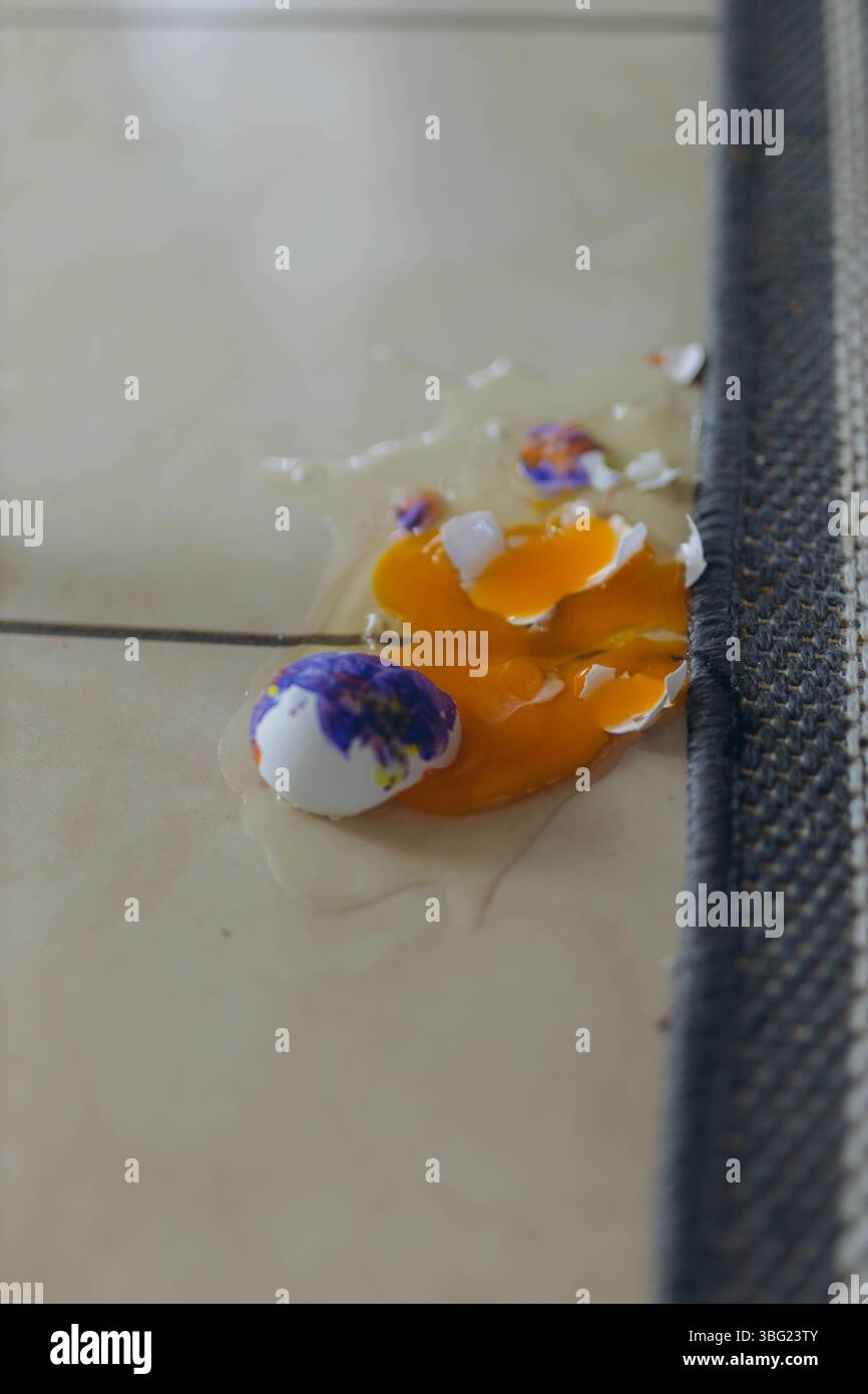 Oeuf cassé dans le sol, ymbolizing les mésaventures de Pâques et les préparations de vacances. Concept de célébration de Pâques Banque D'Images Oeuf cassé dans le sol, ymbolizing les mésaventures de Pâques et les préparations de vacances. Concept de célébration de Pâques Banque D'Images