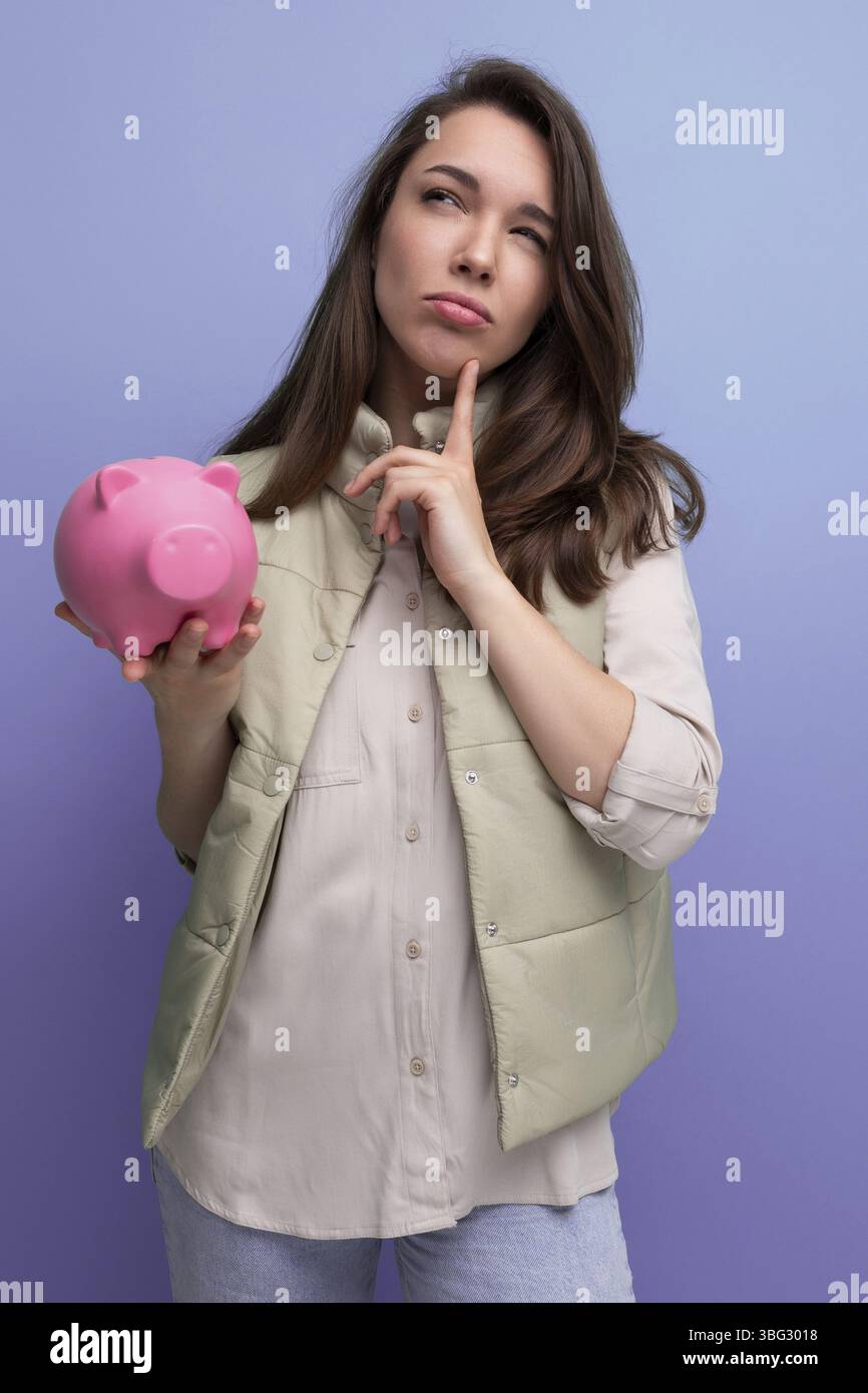 La jeune femme brune décide où investir ses économies de la tirelire Banque D'Images