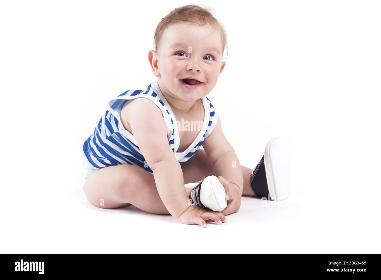 Isolé sur blanc, bébé garçon caucasien en chemise marine et chaussures noires se trouve Banque D'Images